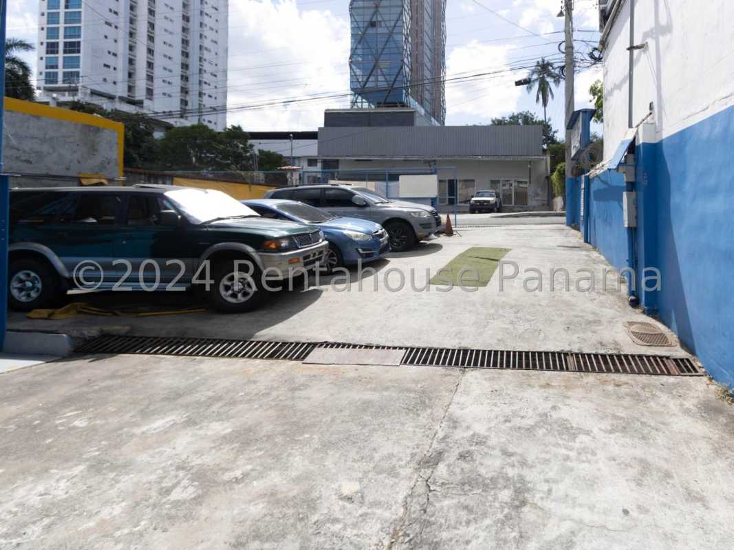 Large paved parking within gated commercial lot with visible city skyline in Panama City