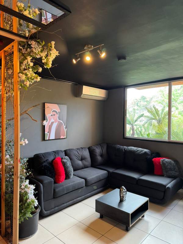 Living room with sectional sofa, large window and AC in PH Mallorca Park Village Los Andes Panama City.
