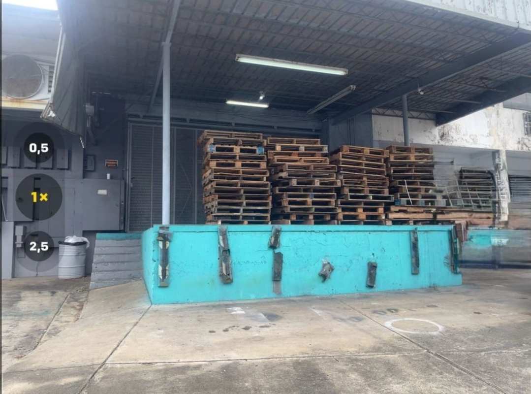 Covered loading area with dock ramp and turquoise platform in industrial warehouse Panama City