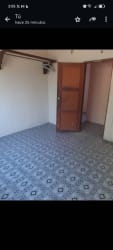 Empty bedroom with tile flooring wood door exposed beams Santiago student rental