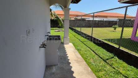 Covered porch with arches and garden lawn in front of house sale in Residencial Aqualina David Chiriquí