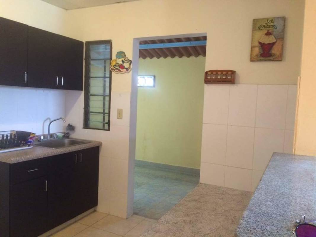 Kitchen space with granite countertop, cabinets, tiled walls and window in PH Valle del Lago Las Cumbres