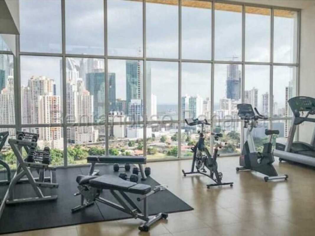 Fitness center with panoramic skyline views and equipment at The One Tower Panama