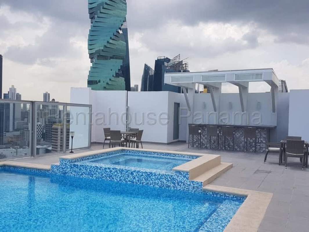 Infinity rooftop pool with glass railing and city skyline at The One Tower Panama