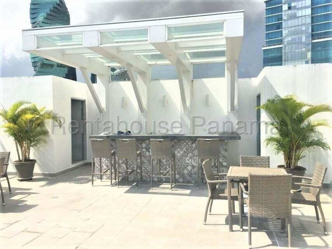 Living-dining space with large windows and skyline views at The One Tower Panama