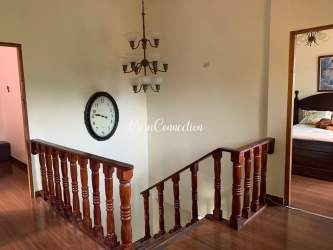 Staircase landing with wood rail chandelier garden view in mountain house Boquete Panama