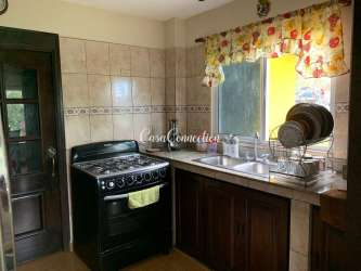 Bedroom with wooden bed large window green curtains mountain views Boquete Panama