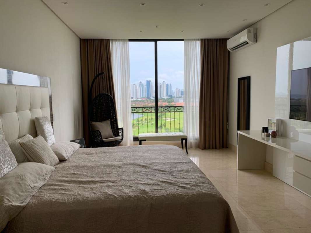Elegant guest bedroom with floor-to-ceiling windows offering panoramic views of the city and green hills in Santa Maria Panama