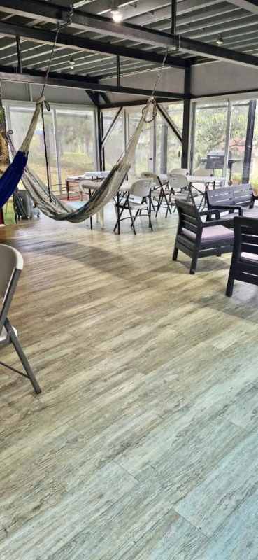 Minimalist bedroom with exposed brick wall, split AC and wood laminate floor in Cerro Viento Panama house for sale