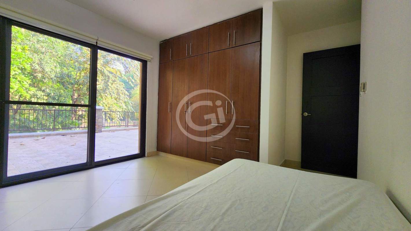 Bedroom with terrace access overlooking lush gardens at Embassy Club Clayton Panama