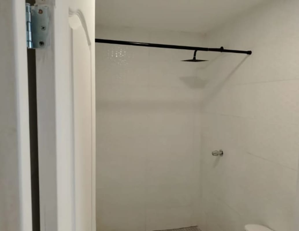 Minimalist bathroom with white tiles, vessel sink on granite, walk-in shower PH Aurora Panama City