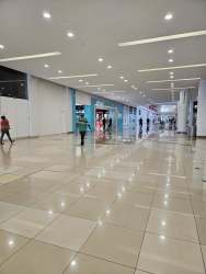Wide shopping mall corridor with tiled floor and storefronts at Wesland Mall Arraiján Panama