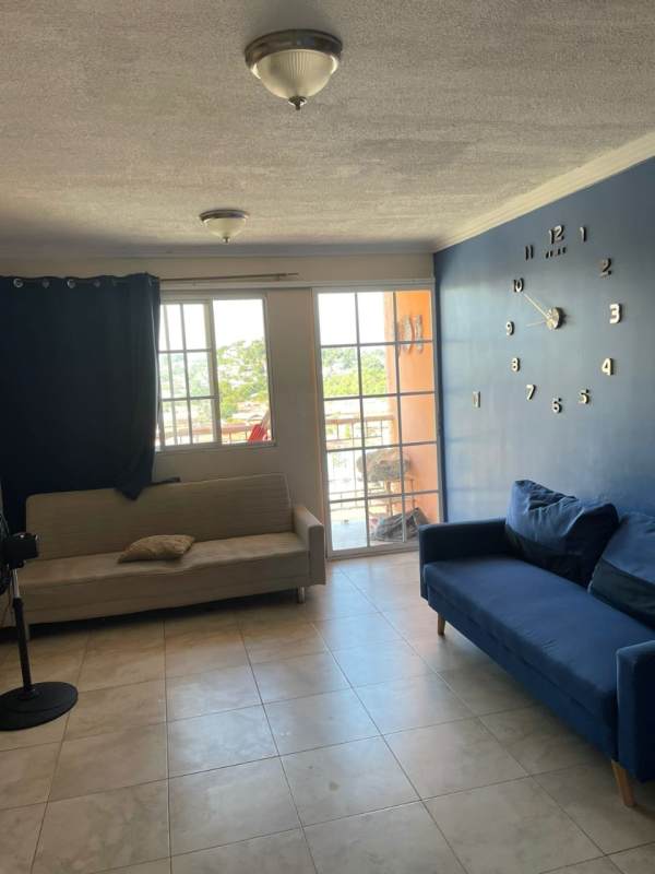 Living room with tiled floors, natural light, blue accent wall and balcony access in Villa Lucre El Crisol Panama