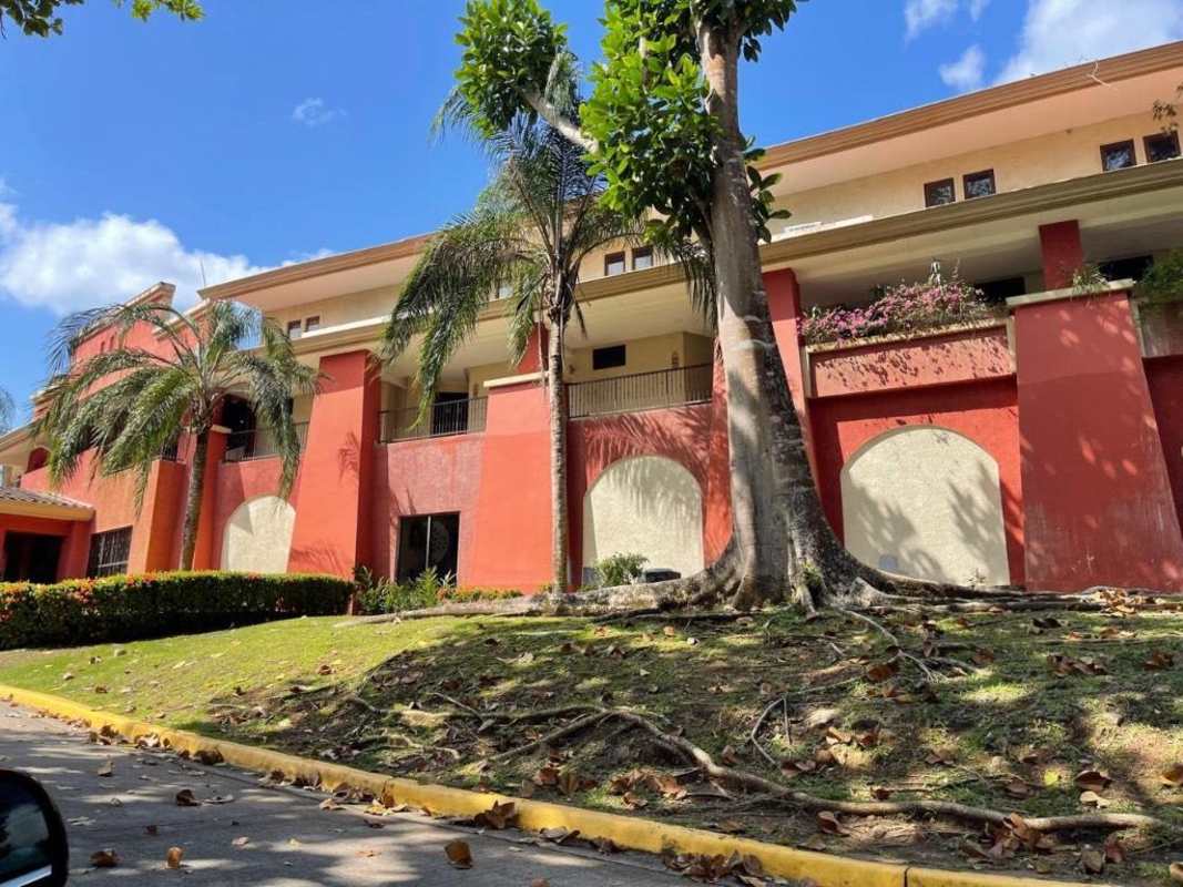 Multistory Mediterranean-style condominium with balconies, gardens, and palm trees at Embassy Club Clayton Panama