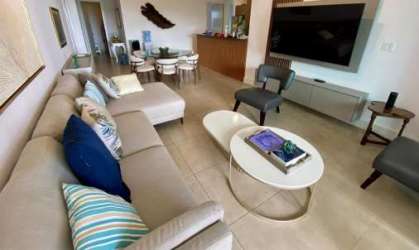 Modern open plan living room dining with large sectional sofa tile floors in luxury beachfront flat Panama