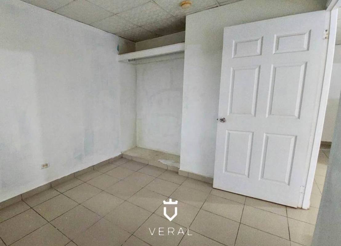 Bedroom with open closet space and neutral tiles in affordable house Praderas de San Lorenzo Panama