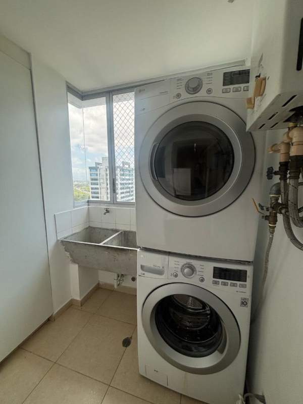 Laundry room with stacked washer dryer, utility sink, large windows PH Sol del Este Costa del Este Panama