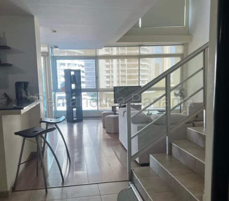Loft living room with double height windows, ocean view balcony in PH Bayfront Panama