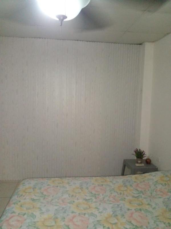 Bedroom with floral bedding, tiled floor, AC, built-in closet at Villa Lucre Panama rental