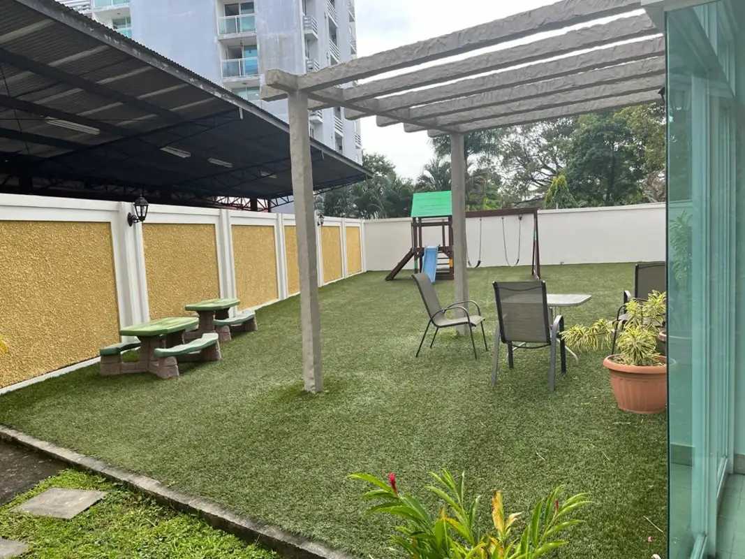 Children's play area with pergola, artificial lawn, playground equipment at PH Albrook Clayton