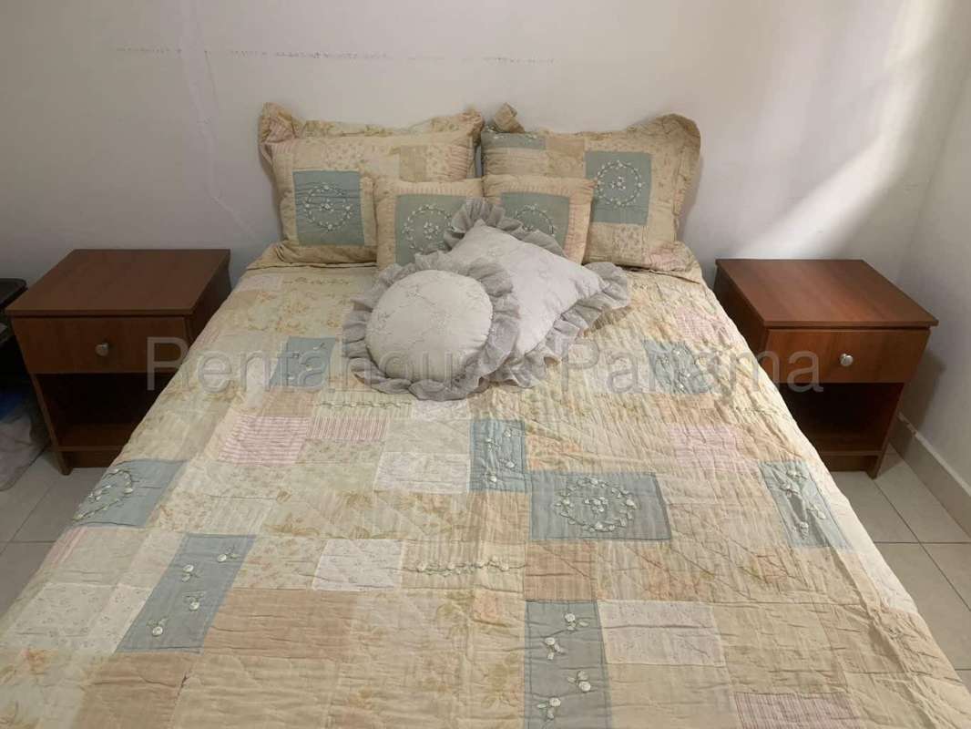 Bedroom with tufted headboard, neutral palette, bedside table in Condado del Rey Panama