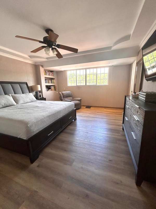 Master bedroom with wood flooring, ceiling fan, large window and AC in Cardenas near Clayton