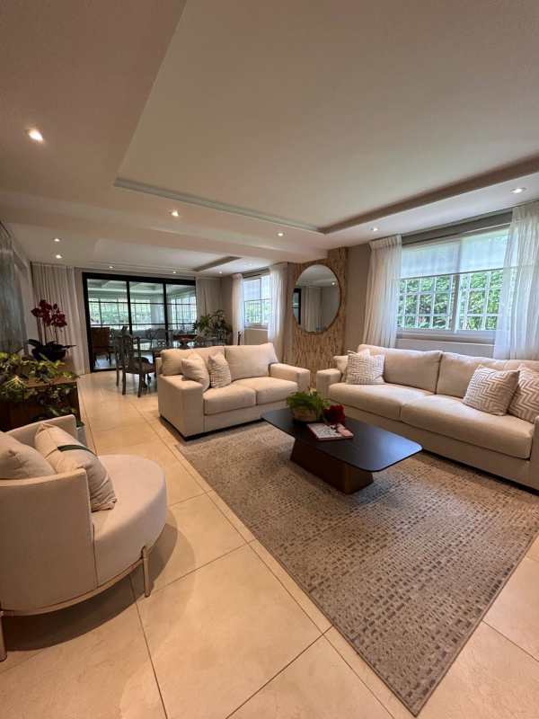 Open plan living room with large windows, ceiling fan and neutral decor in Clayton Panama