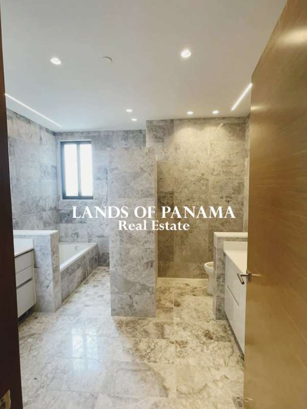 Luxury bathroom with marble finishes, bathtub, glass shower, and double vanity in Empire Residences Panama City