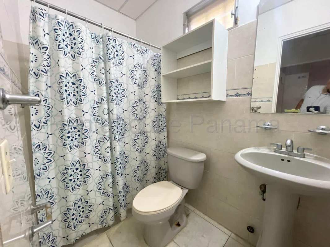 Bathroom with pedestal sink, tiled walls, and shower with curtain in San Antonio Panama