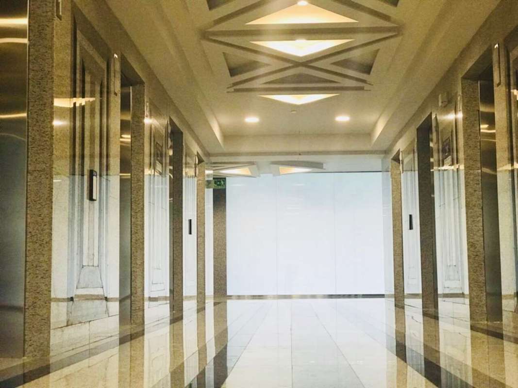 Unfinished interior with concrete ceilings and floor-to-ceiling windows overlooking city skyline Evolution Tower