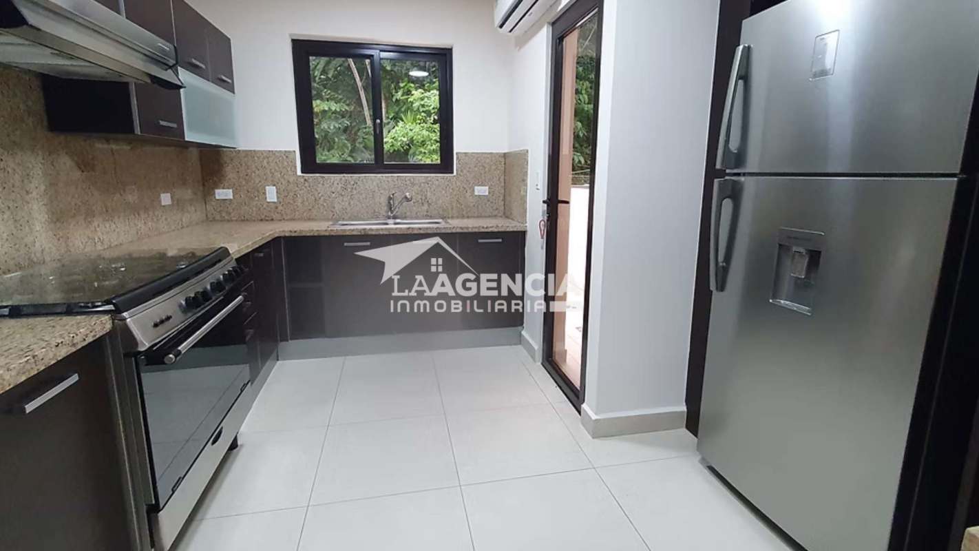 Contemporary kitchen with granite countertops and stainless appliances overlooking forest