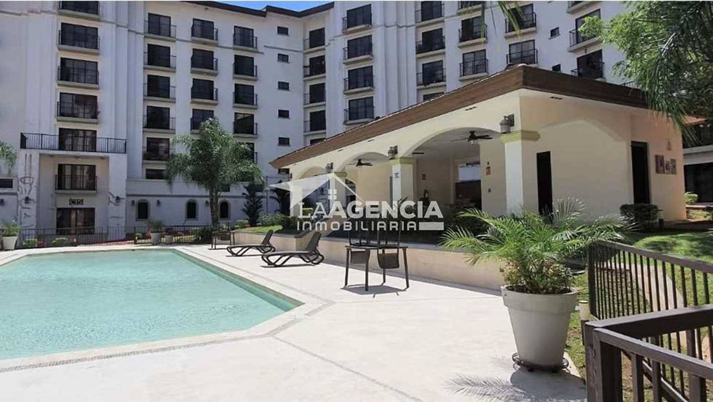 Swimming pool and sun loungers in apartment complex Embassy Village Panama