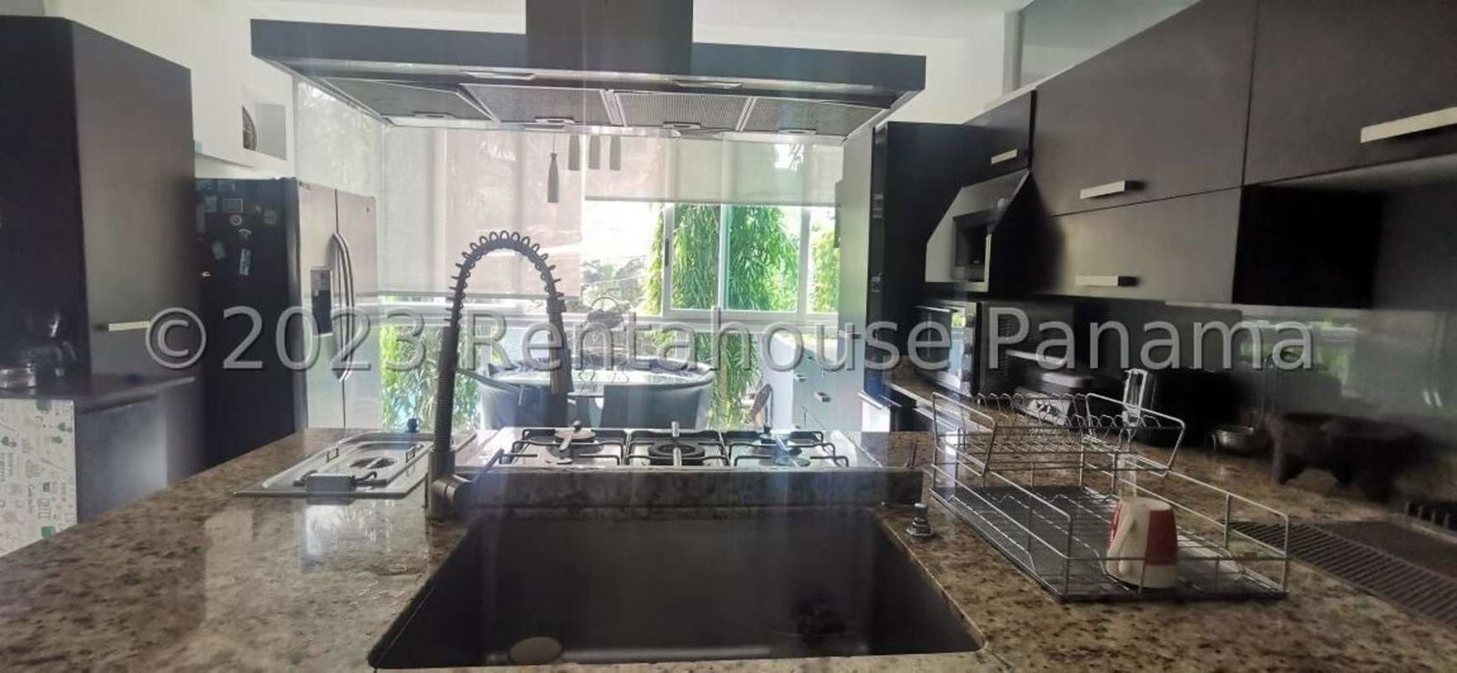 Dining room with garden view, glass table, white chairs, in modern Albrook Panama City rental