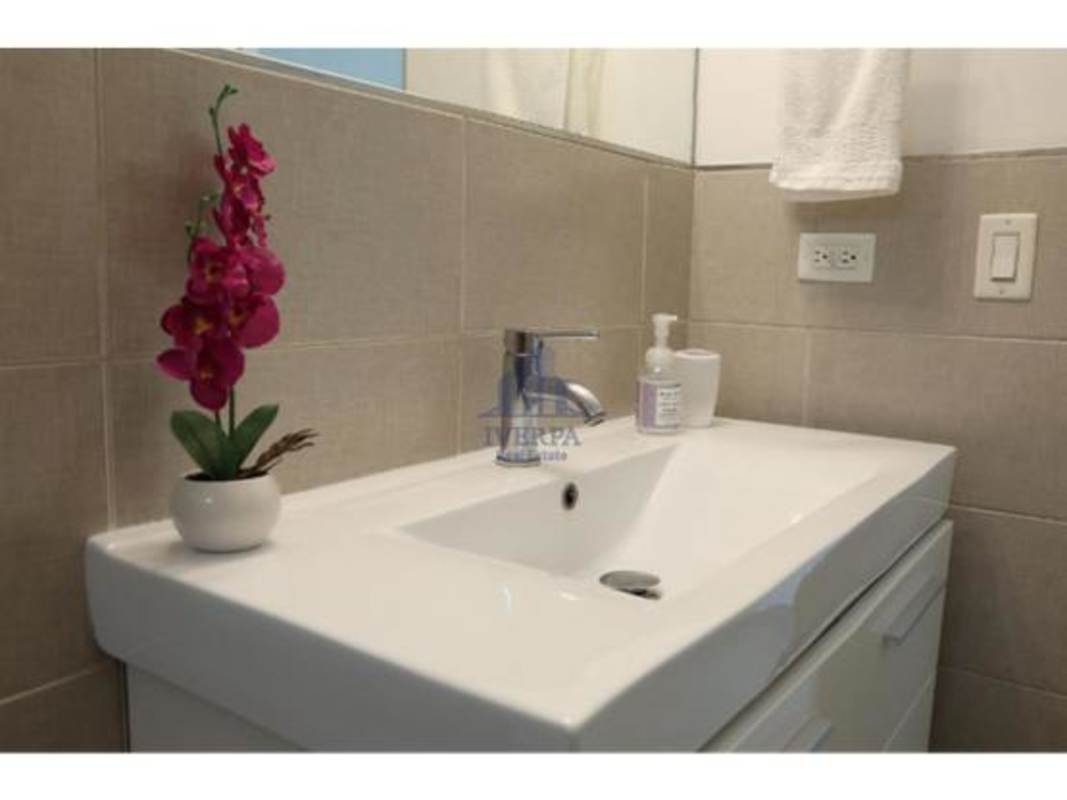 Modern bathroom with ceramic sink vanity mirror and beige tiles PH San Francisco Panama