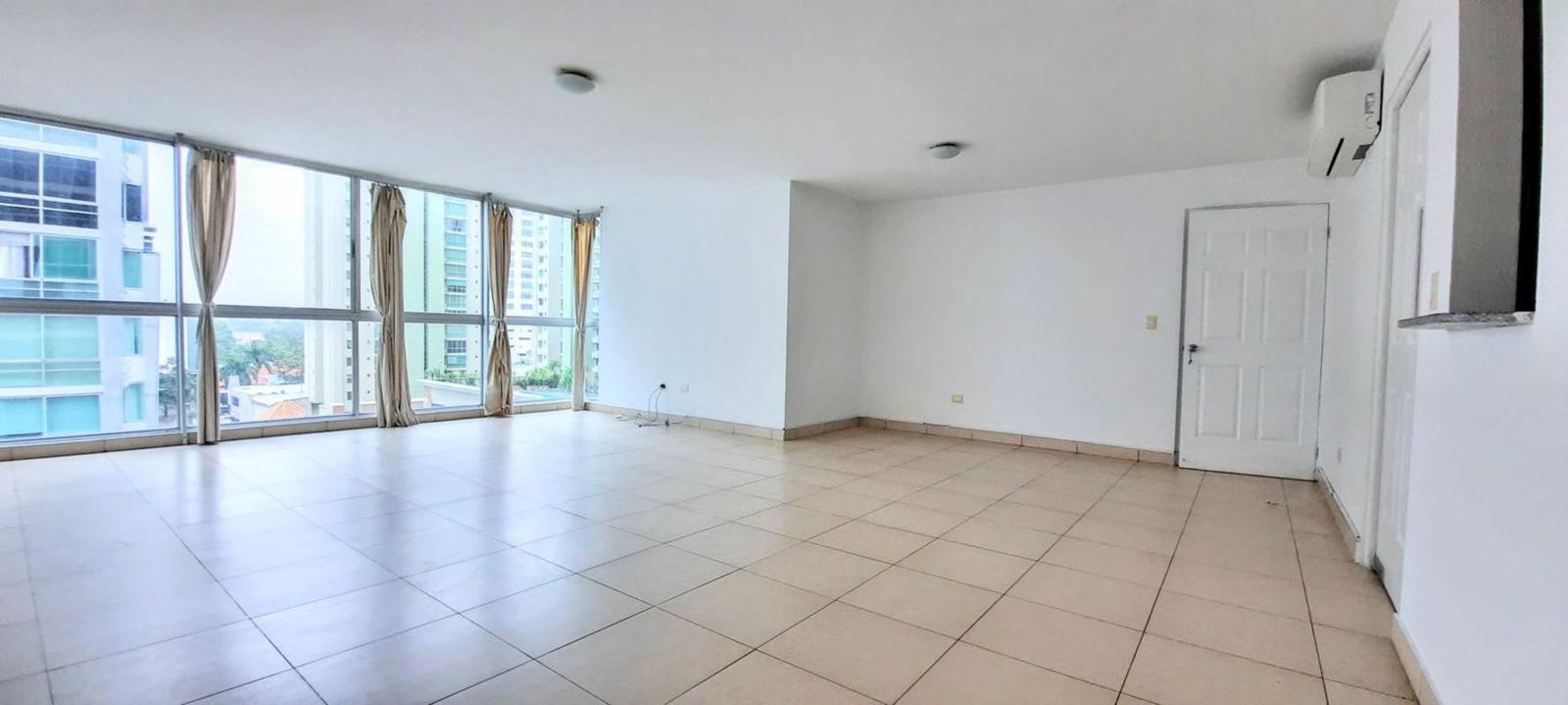 Bright living room with panoramic windows and tile flooring in apartment for sale PH Serenade Panama City