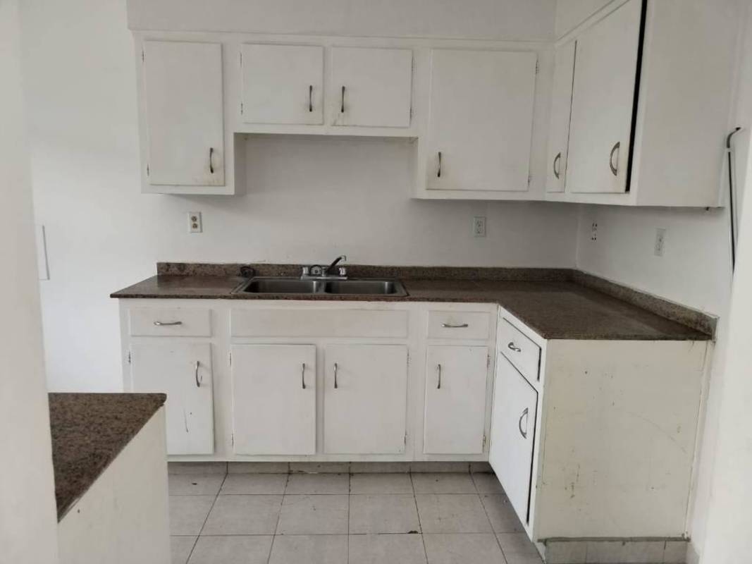 Kitchen with white cabinets and dark countertop in Clayton apartment Panama