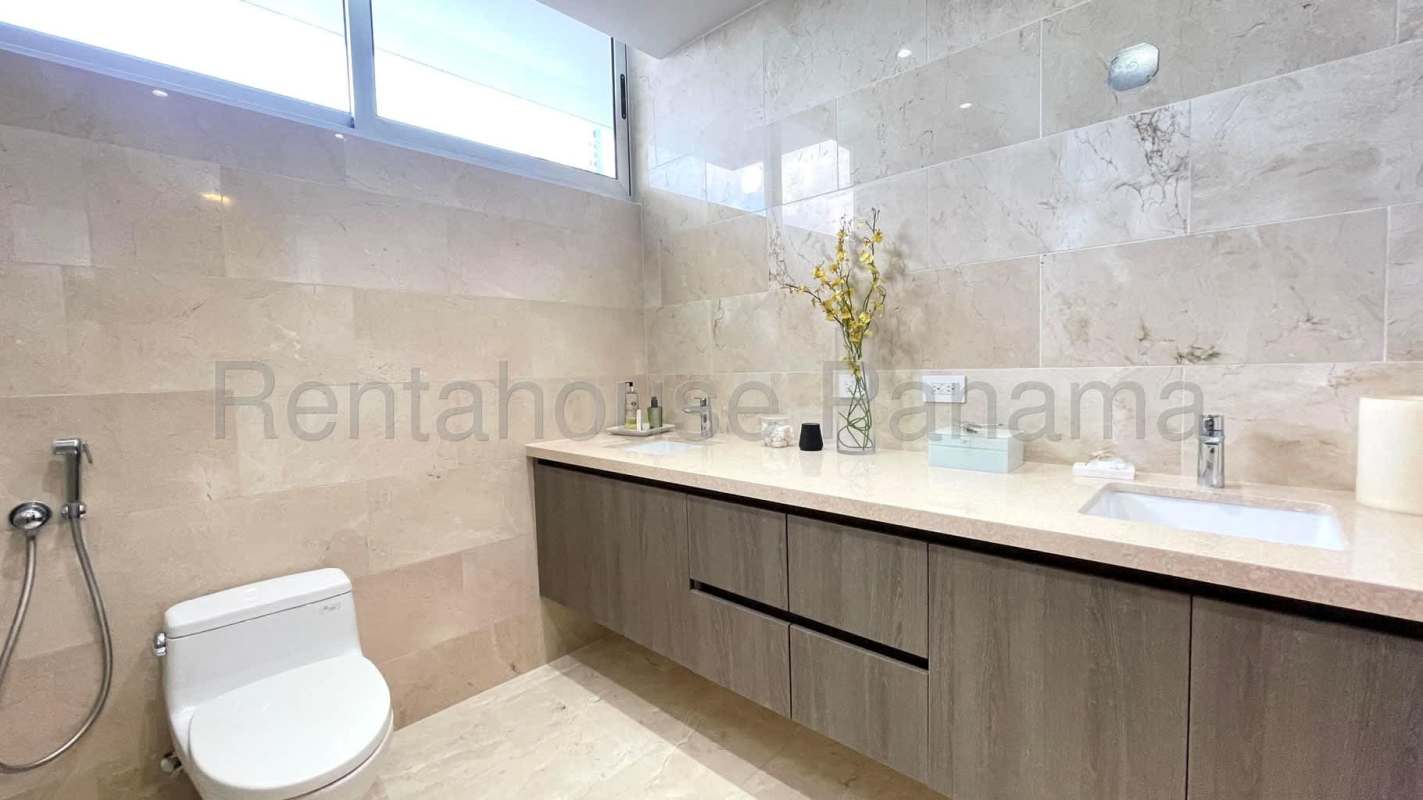Modern bathroom with glass shower enclosure, marble floors, and dual sink vanity in PH Coco del Mar Panama City