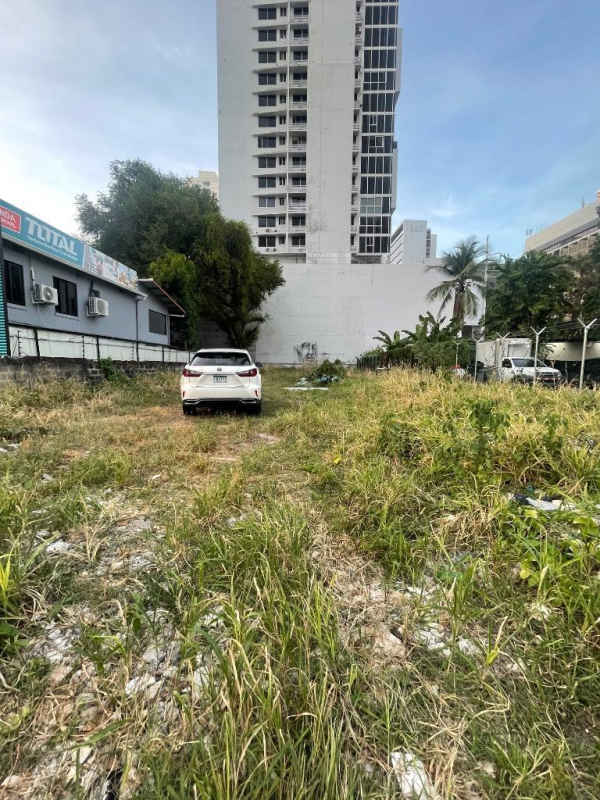 Commercial vacant lot with white car and multi-story buildings on Avenida Principal in San Francisco Panama City