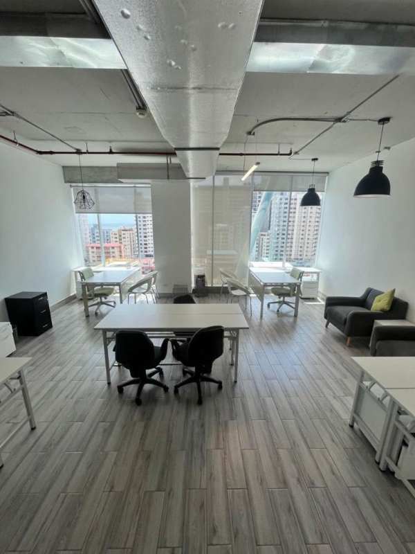 Open modern office floor with exposed ceilings and panoramic windows in PH Office 77 Panama