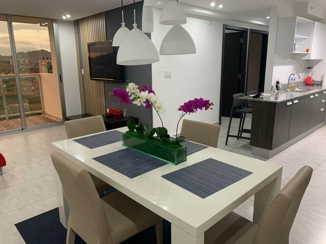 Modern open kitchen with granite counters connected to dining and living area in Condado Gardens Panama City