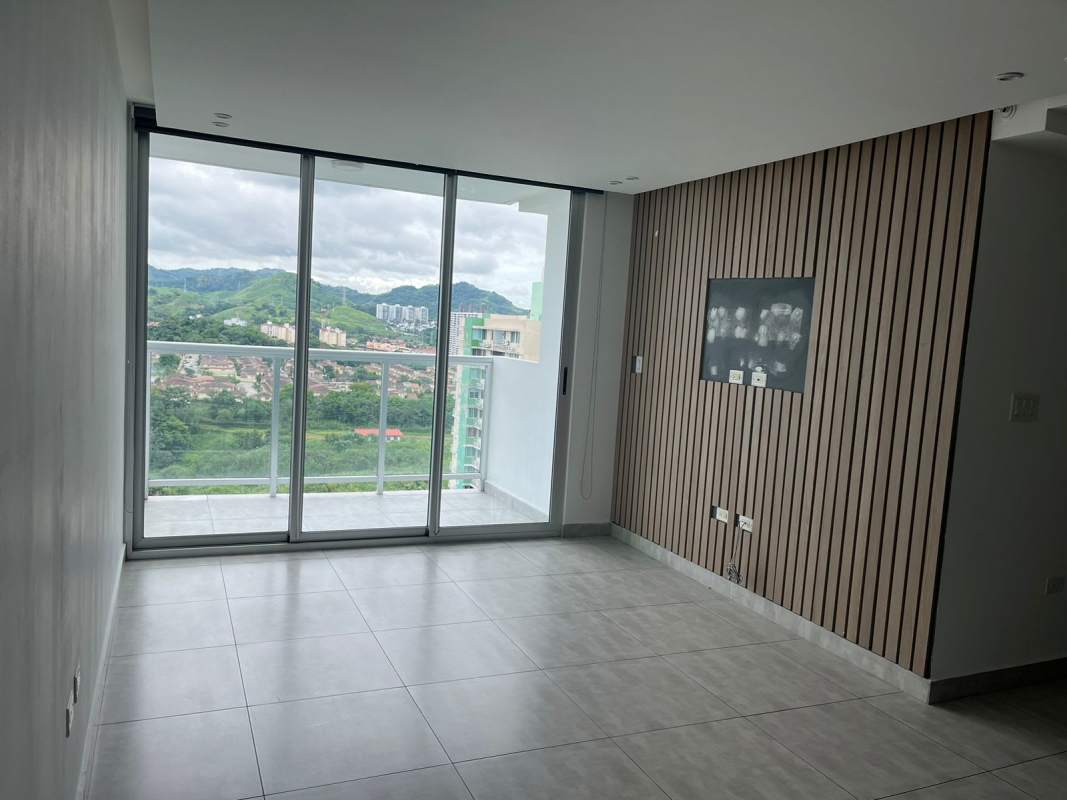 Spacious living and dining room with sliding glass doors to balcony in Condado Gardens Panama City