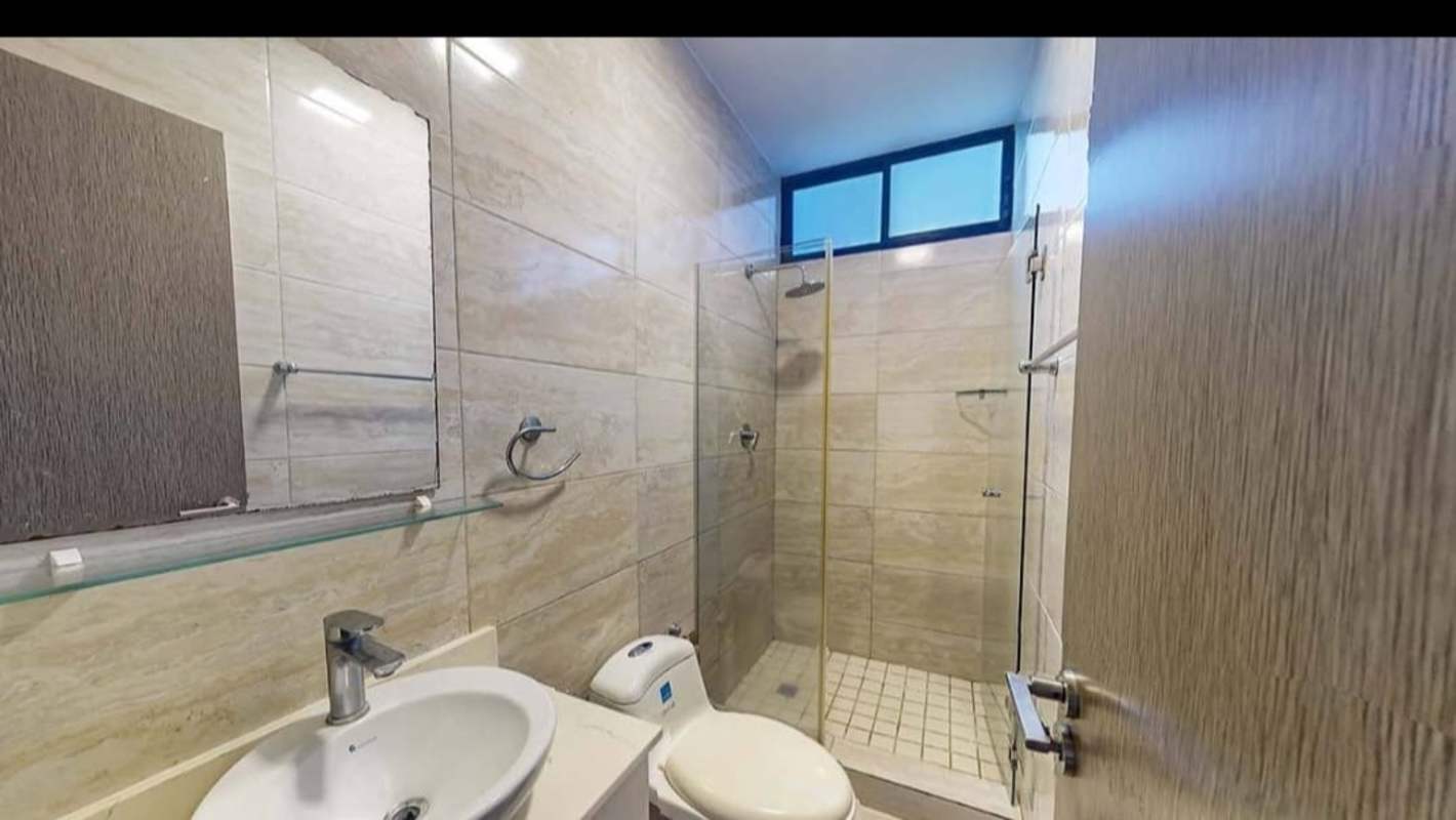 Bathroom with glass shower enclosure, tiled walls and modern fixtures at PH Canvas Tower Panama City