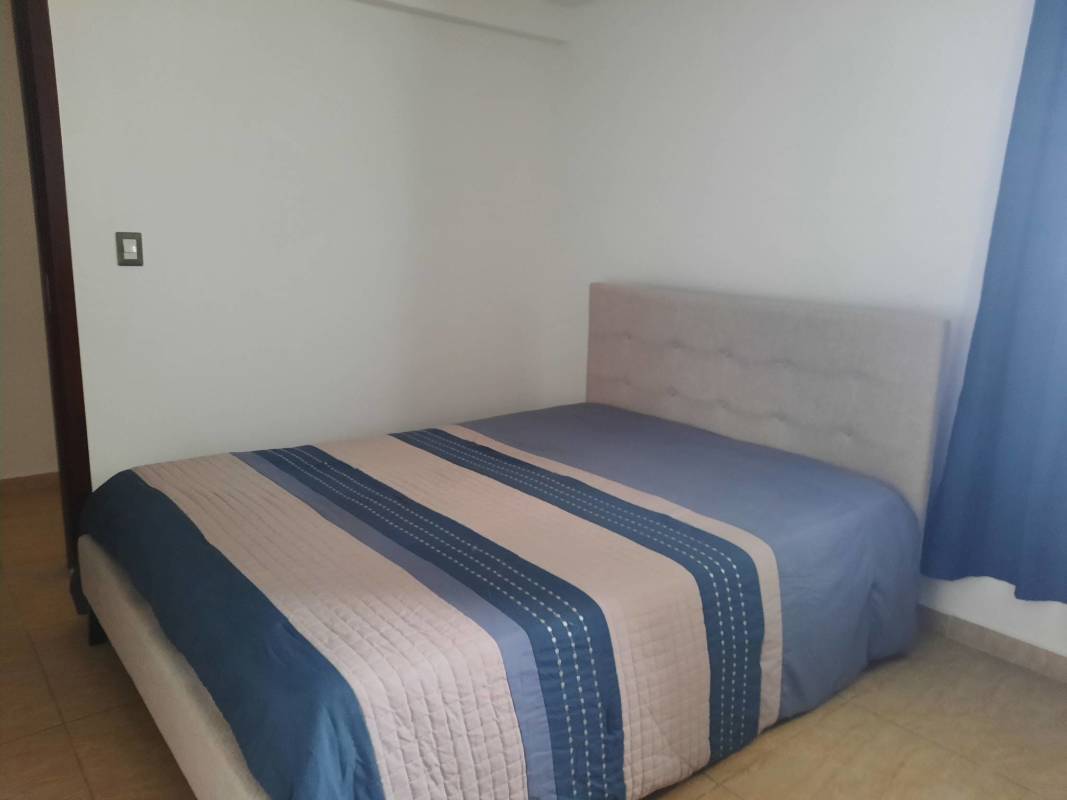 Minimalist bedroom with tile floor striped bedding PH Terrazas del Rey Panama