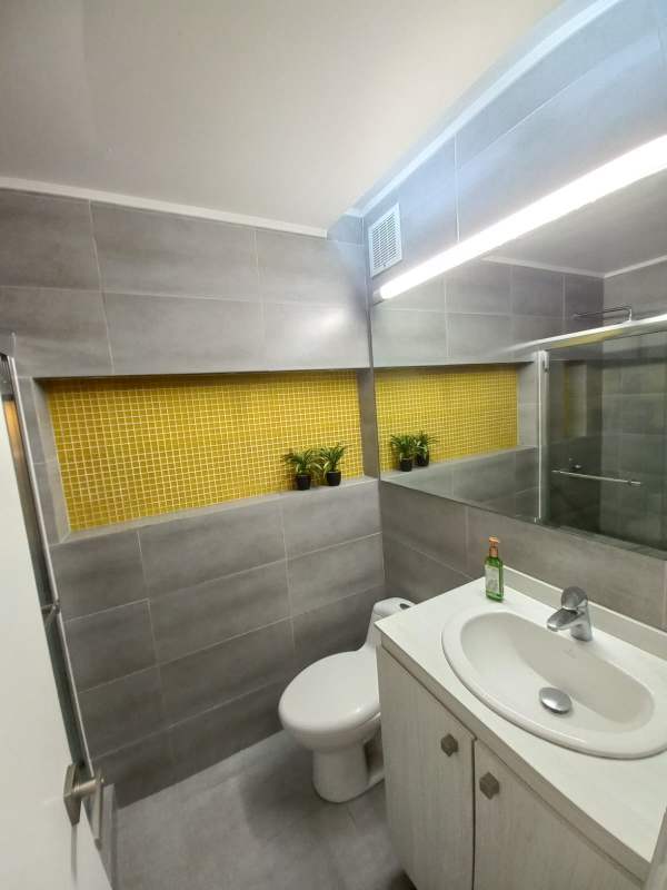 Contemporary renovated bathroom with gray tiles, mosaic yellow wall, glass shower in PH Altamira San Francisco