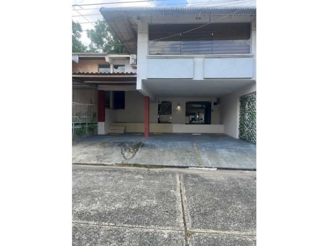 Covered parking space with brick pillars and lighting at Altos del Golf multifunctional house