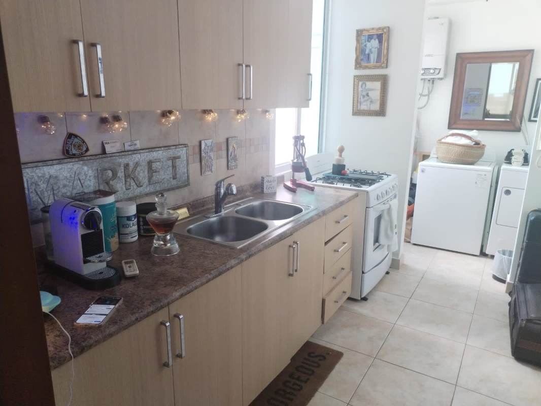 Open kitchen with granite counters, wood cabinets, washer dryer PH Marquis Tower Panama