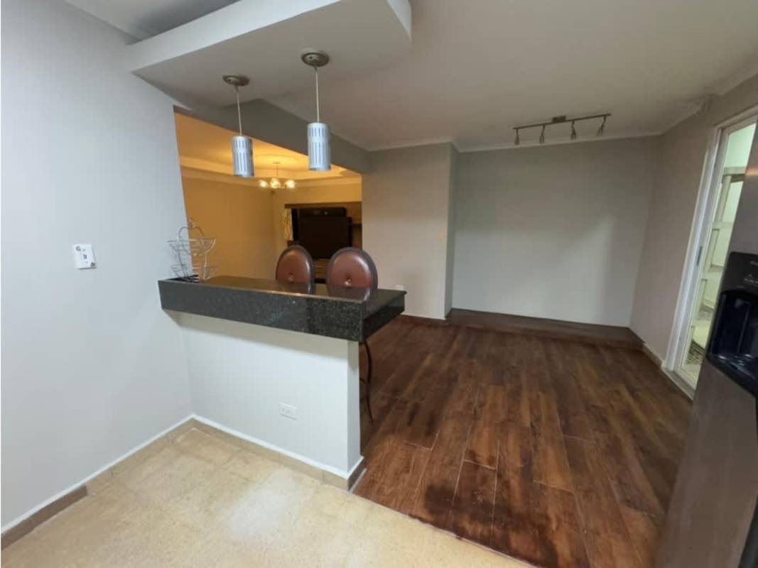 Modern open kitchen with granite-style breakfast bar and dining area in house for sale Las Americas Panama