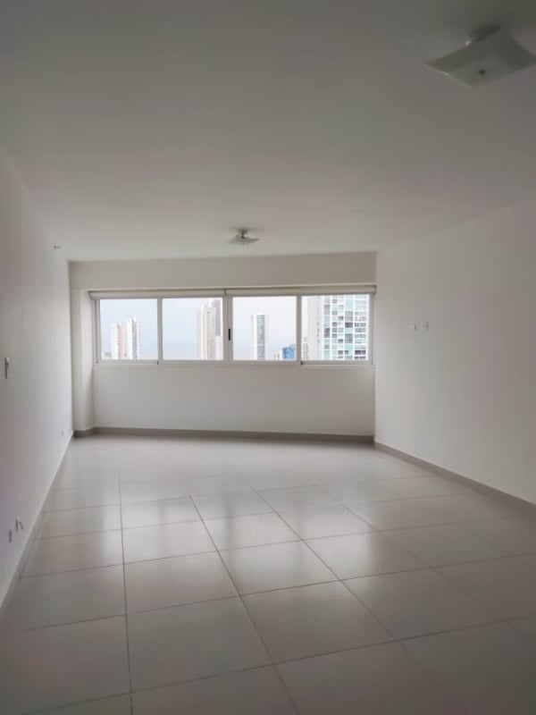 Living room with large windows, balcony access, and ocean views at PH Vista del Parque San Francisco Panama City