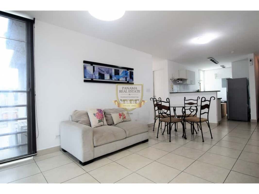 Open concept living dining space with beige sofa and balcony access at PH Los Toneles Panama City