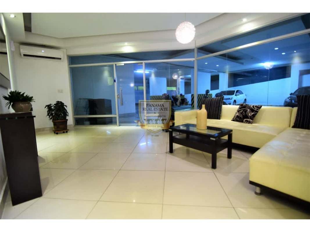 Living room with sectional sofa, glass windows and modern decor PH Los Toneles Panama